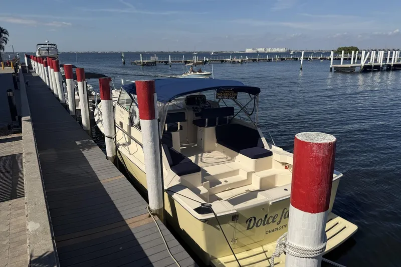 Slide: The Image of 2004 Mainship Pilot 34 Sedan docked at a marina with scenic water view. - 73