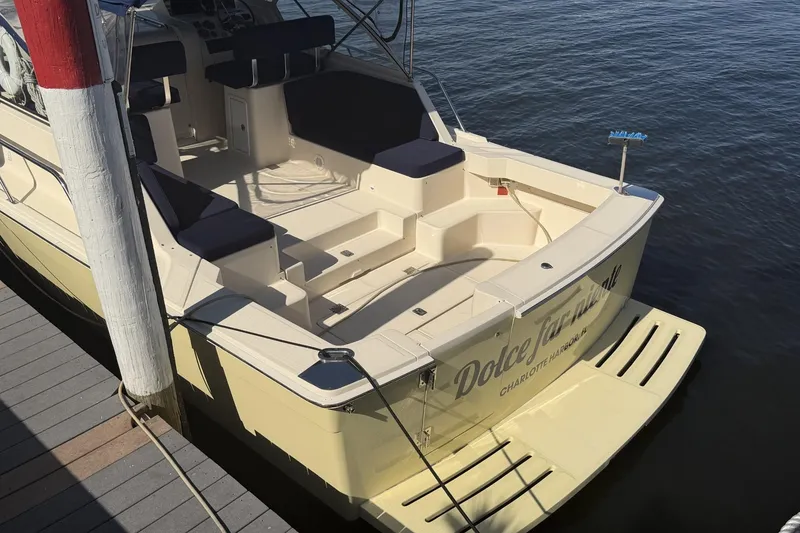 Slide: The Image of 2004 Mainship Pilot 34 Sedan docked, featuring spacious deck and seating area. - 74