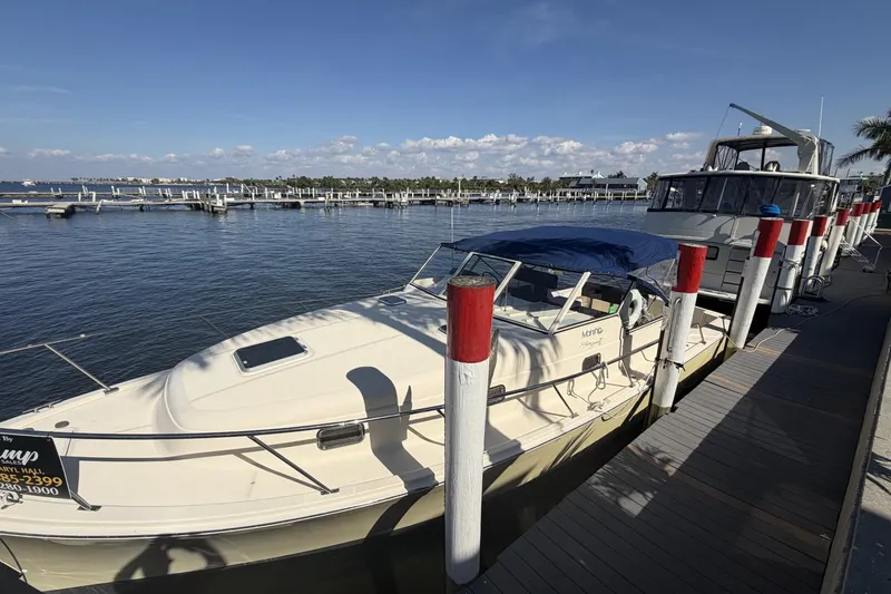 Slide: The Image of 2004 Mainship Pilot 34 Sedan docked at marina under clear blue sky. - 76