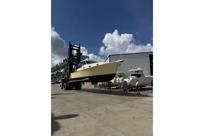 Slide: The Image of 2004 Mainship Pilot 34 Sedan being transported at a marina under a clear blue sky. - 79