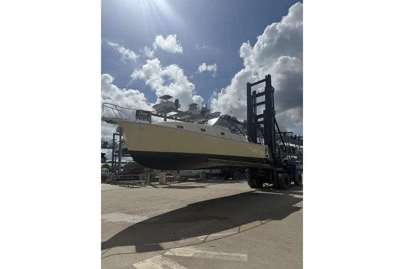 Slide: The Image of 2004 Mainship Pilot 34 Sedan on forklift under cloudy sky. - 80