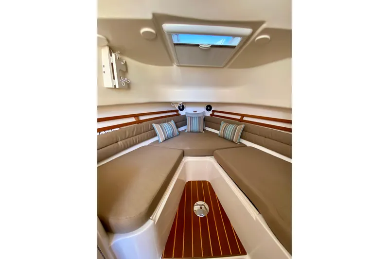 Slide: The Image of 2017 Grady-White Marlin 300 cabin interior with cushions and striped pillows. - 13