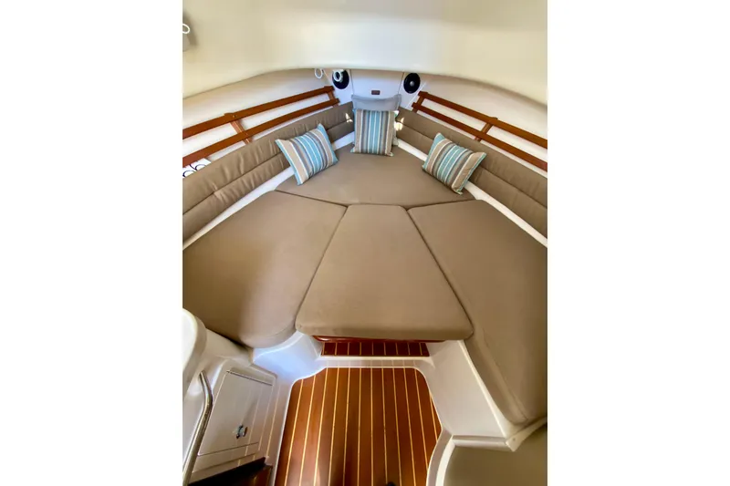 Slide: The Image of 2017 Grady-White Marlin 300 cabin interior with cushioned seating and striped pillows. - 15