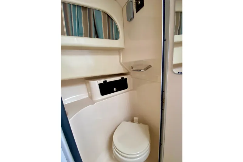 Slide: The Image of 2017 Grady-White Marlin 300 boat bathroom interior with toilet and storage. - 16