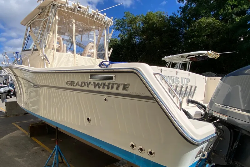 Slide: The Image of 2017 Grady-White Marlin 300 boat with outboard motor, docked under blue sky. - 2