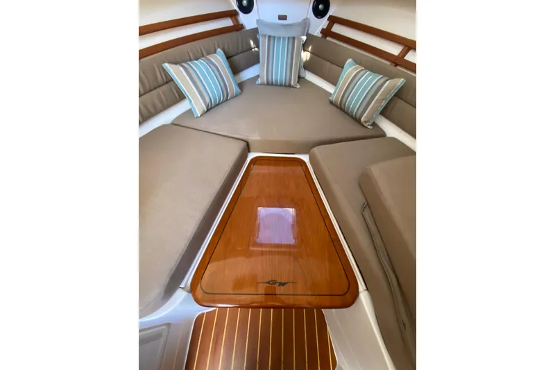 Slide: The Image of 2017 Grady-White Marlin 300 cabin interior with cushioned seating and striped pillows. - 25