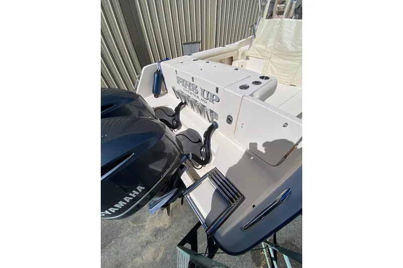 Slide: The Image of 2017 Grady-White Marlin 300 boat with Yamaha engines, docked near a metal building. - 4