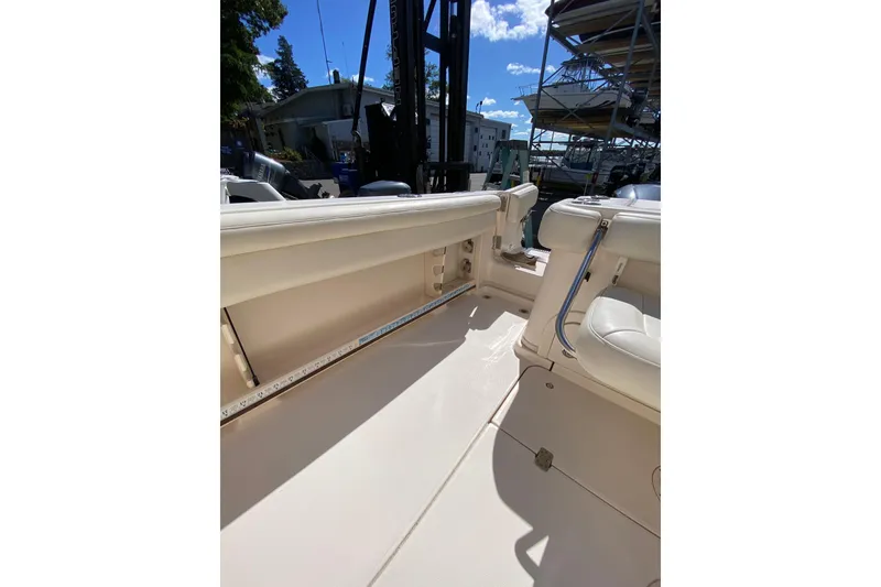 Slide: The Image of 2017 Grady-White Marlin 300 boat interior with seating and storage, docked under clear skies. - 6