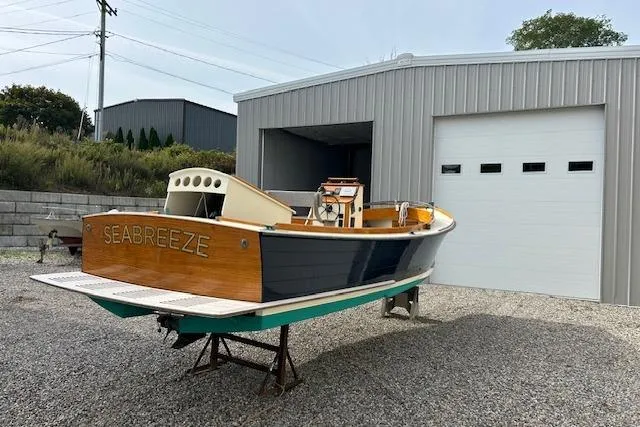 Slide: The Image of First Light Monomoy 26 boat 'Seabreeze' from 2016, displayed outside a metal garage. - 5