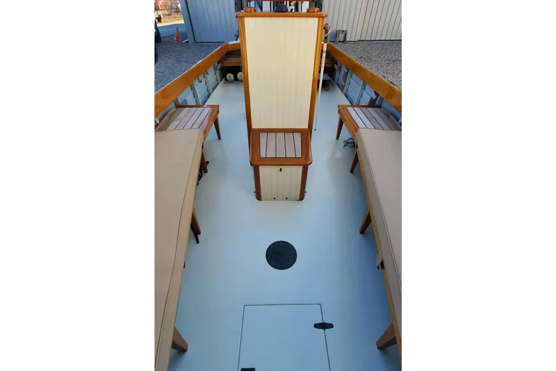 Slide: The Image of Interior of 2016 First Light Monomoy 26 boat with wooden benches and central seat. - 14