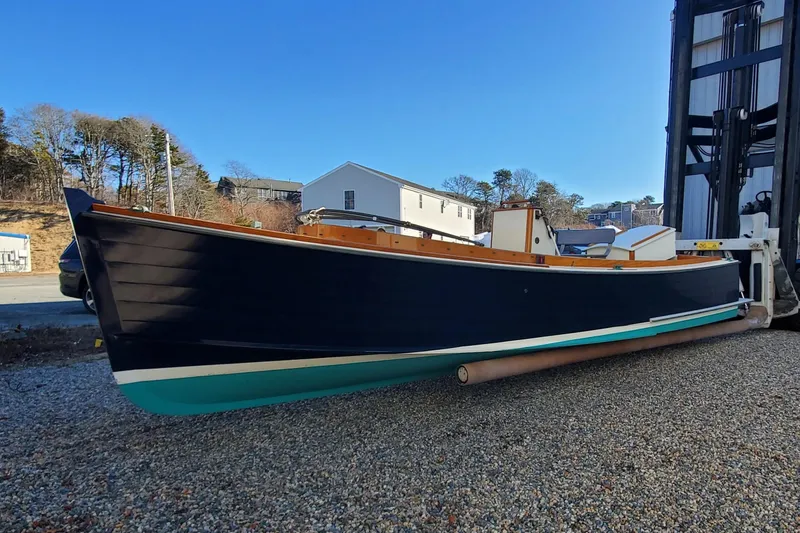 Slide: The Image of First Light Monomoy 26 boat, 2016 model, displayed outdoors on gravel. - 2