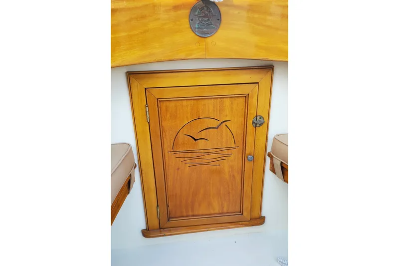 Slide: The Image of Wooden cabin door with engraved sunset design on a 2016 First Light Monomoy 26 boat. - 11