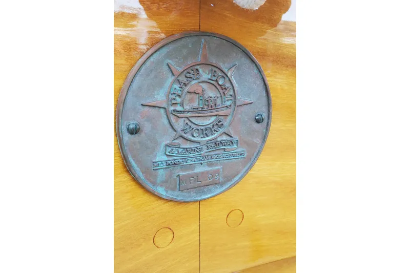 Slide: The Image of Plaque on First Light Monomoy 26 boat, 2016 model, featuring Pease Boat Works emblem. - 13