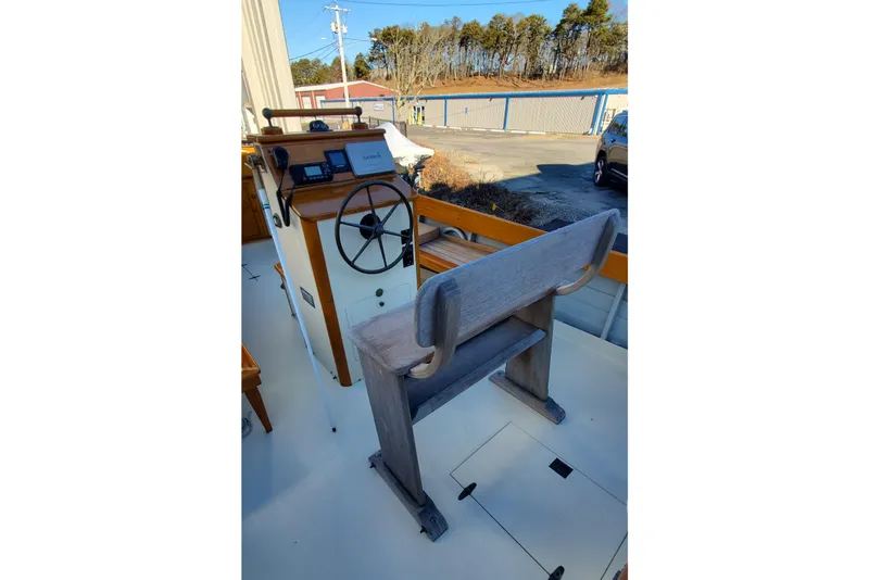 Slide: The Image of Helm of 2016 First Light Monomoy 26 boat with wooden bench and steering wheel. - 9