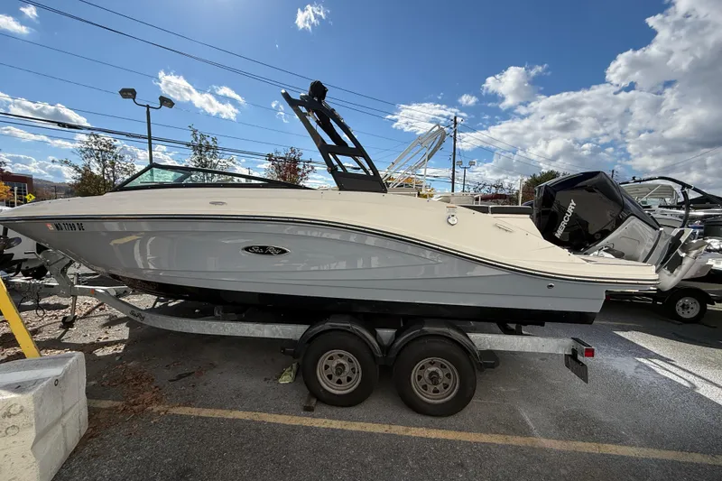The Image of 2023 Sea Ray SPX 230 Outboard boat on trailer under a clear blue sky. - 0