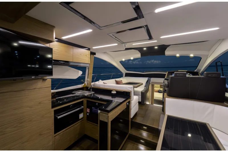 Slide: The Image of Luxurious interior of 2026 Cobrey 52 FLY yacht with modern kitchen and seating area. - 13