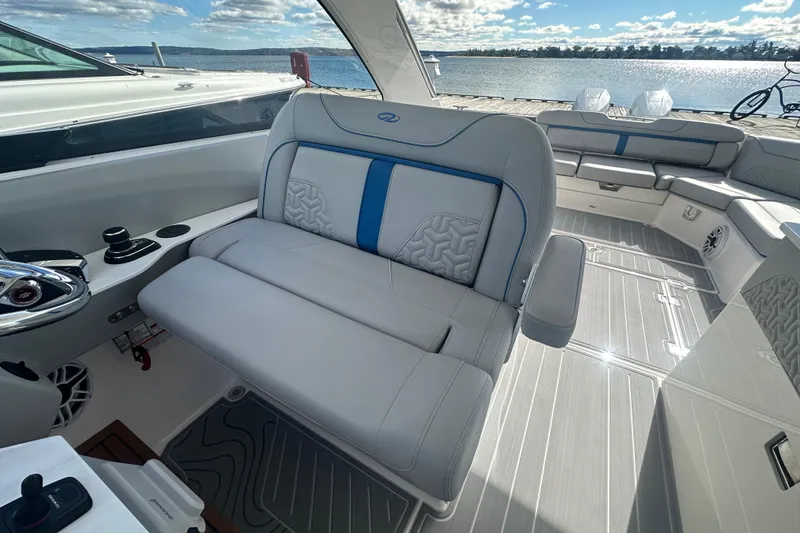 Slide: The Image of 2025 Regal LX36 boat interior with luxurious seating and modern design by the water. - 12