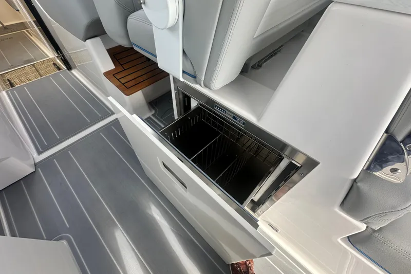 Slide: The Image of 2025 Regal LX36 boat interior with open storage compartment and sleek seating. - 15
