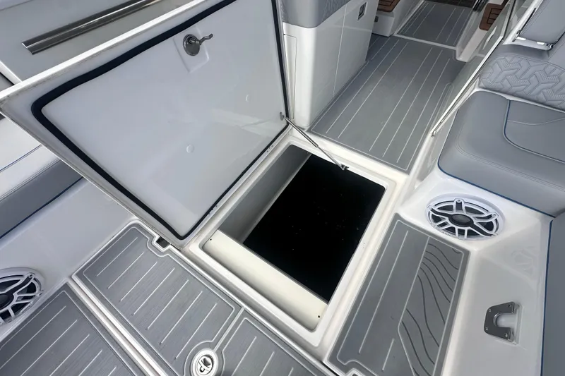 Slide: The Image of 2025 Regal LX36 boat interior with open storage compartment and sleek gray flooring. - 22