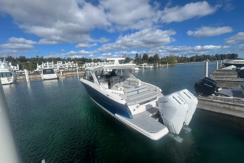 Slide: The Image of 2025 Regal LX36 boat docked in a marina under a clear blue sky. - 3