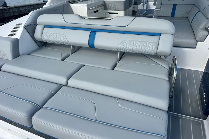 Slide: The Image of 2025 Regal LX36 boat interior with luxurious gray seating and blue accents. - 34