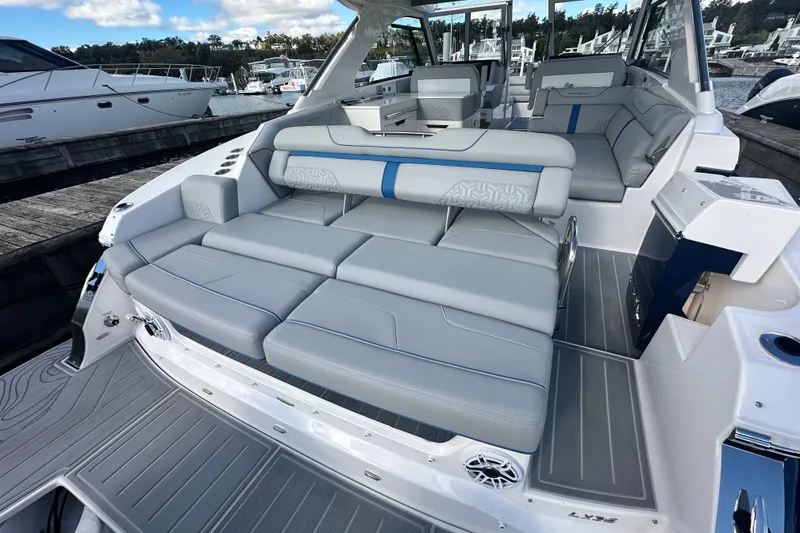 Slide: The Image of 2025 Regal LX36 luxury boat interior with plush seating at a marina. - 35
