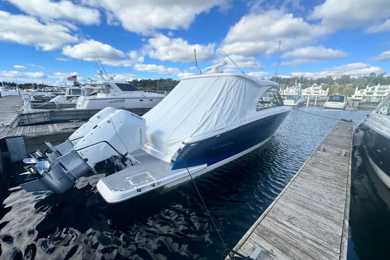 Slide: The Image of 2025 Regal LX36 boat docked at marina under blue sky. - 4