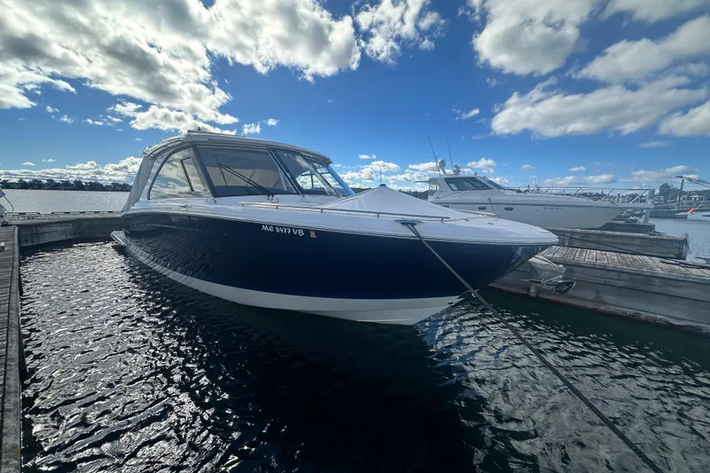 Slide: The Image of 2025 Regal LX36 boat docked at marina under a partly cloudy sky. - 6