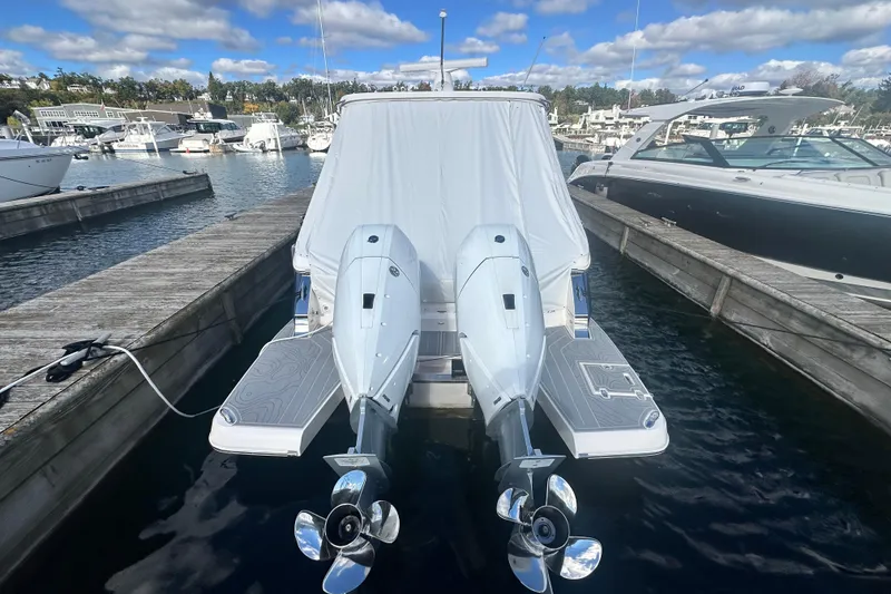 Slide: The Image of 2025 Regal LX36 boat docked with twin outboard motors, covered, in a marina setting. - 7