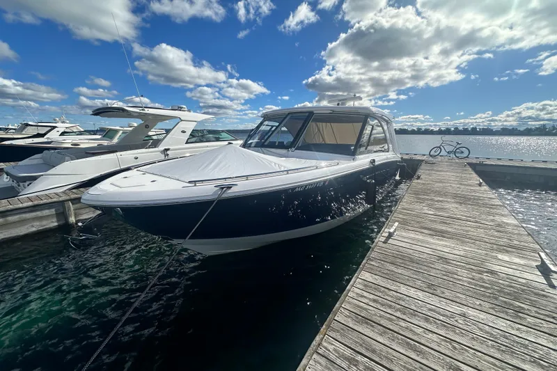 Slide: The Image of 2025 Regal LX36 boat docked at marina under blue sky with clouds. - 8