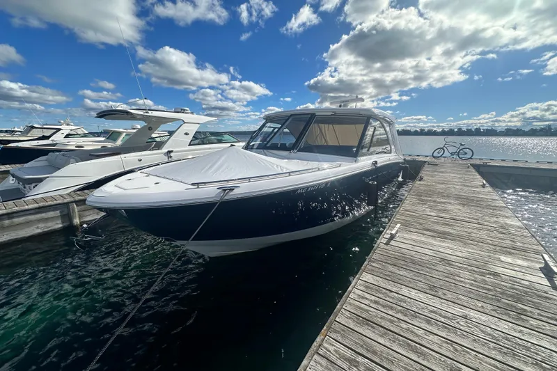 Slide: The Image of 2025 Regal LX36 boat docked at marina under blue sky. - 9