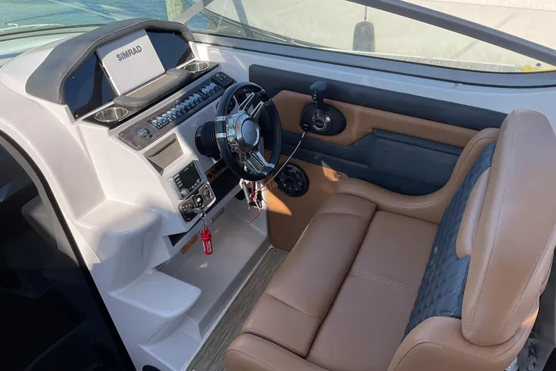 Slide: The Image of 2019 Rinker 290 Express Cruiser helm with Simrad display and leather seating. - 10
