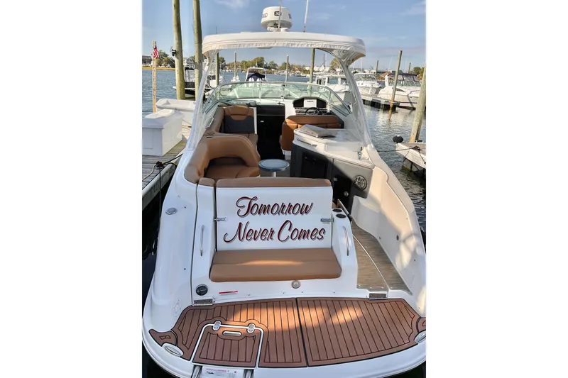 Slide: The Image of 2019 Rinker 290 Express Cruiser docked, featuring "Tomorrow Never Comes" on the seating. - 2