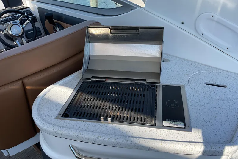 Slide: The Image of 2019 Rinker 290 Express Cruiser with onboard grill and steering wheel. - 7