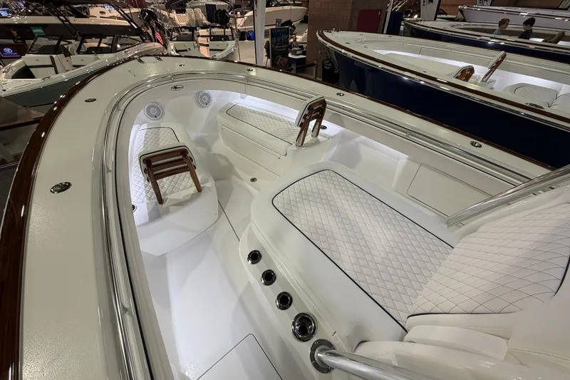 Slide: The Image of 2026 Valhalla Boatworks V-33 interior with white quilted seating and wooden accents. - 4