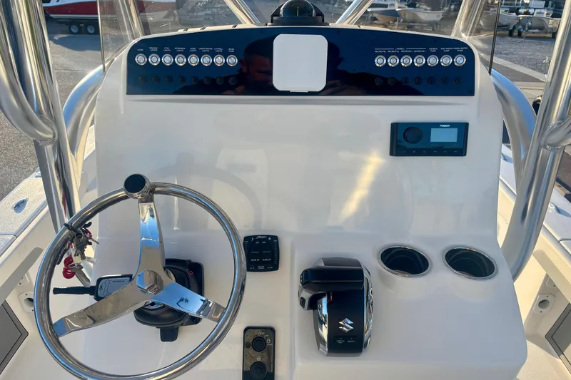Slide: The Image of 2026 Avenger AV26 boat console with steering wheel, controls, and cup holders. - 15