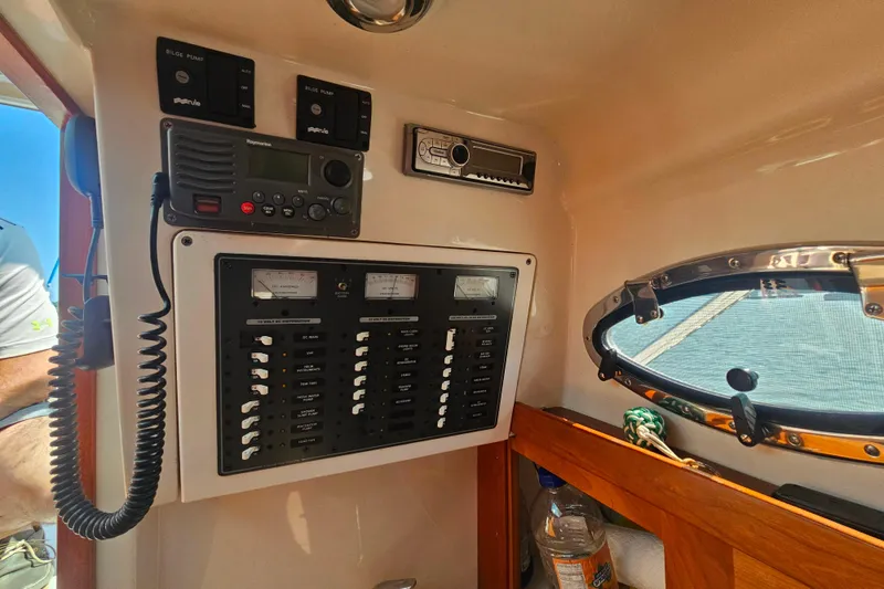 Slide: The Image of Control panel of a 2006 Back Cove 26 boat with radio and switches. - 12