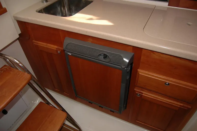 Slide: The Image of 2006 Back Cove 26 boat interior with wooden cabinetry and compact sink. - 15