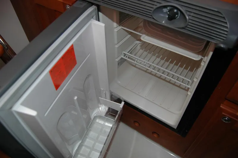 Slide: The Image of Open refrigerator inside a 2006 Back Cove 26 boat, showing empty shelves. - 16