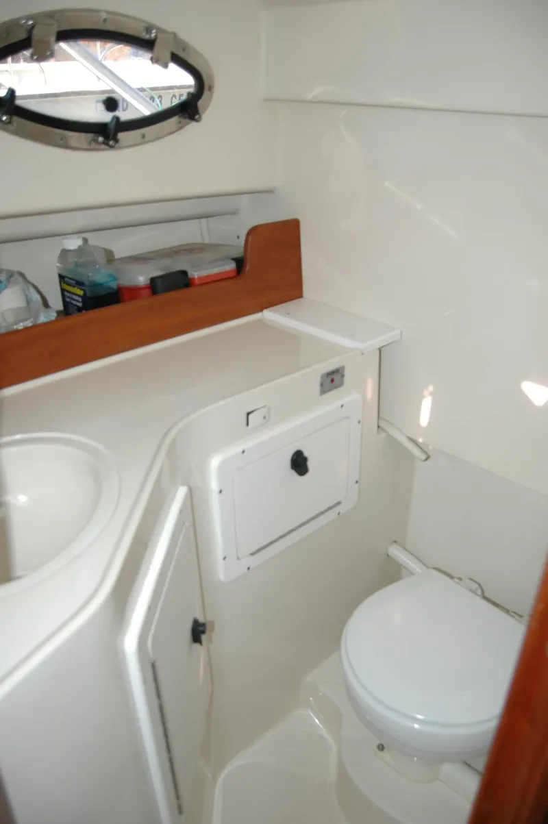 Slide: The Image of 2006 Back Cove 26 boat bathroom with sink, toilet, and storage. - 18