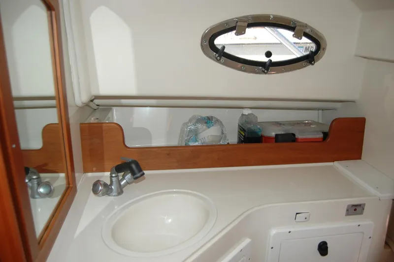 Slide: The Image of 2006 Back Cove 26 boat interior with sink, mirror, and porthole window. - 19