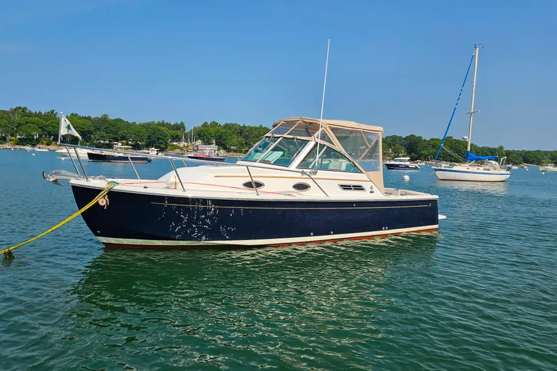 Slide: The Image of 2006 Back Cove 26 boat anchored in a scenic harbor with sailboats. - 2