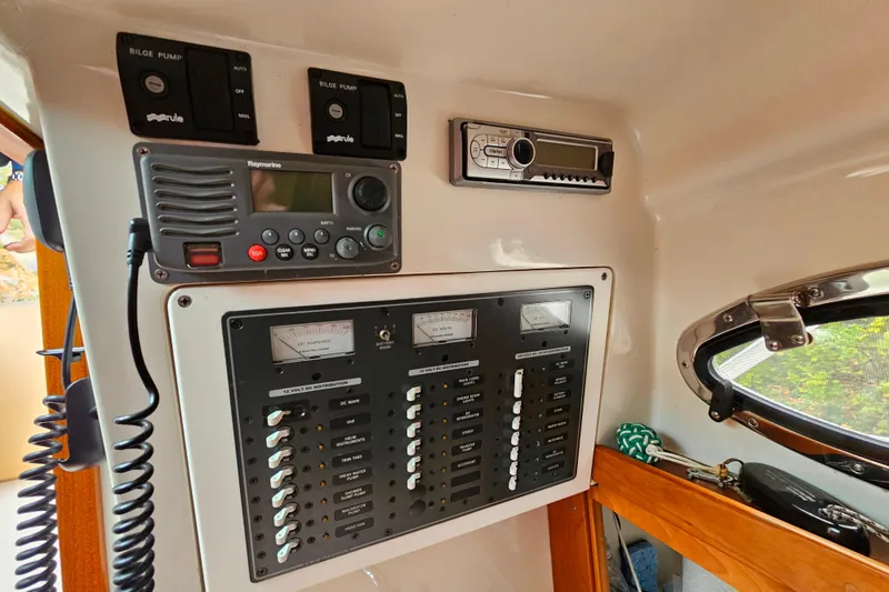Slide: The Image of Control panel of a 2006 Back Cove 26 boat with radio and switches. - 39