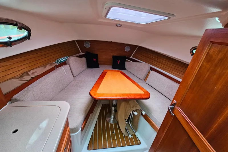 Slide: The Image of 2006 Back Cove 26 cabin interior with wood accents and cozy seating area. - 43