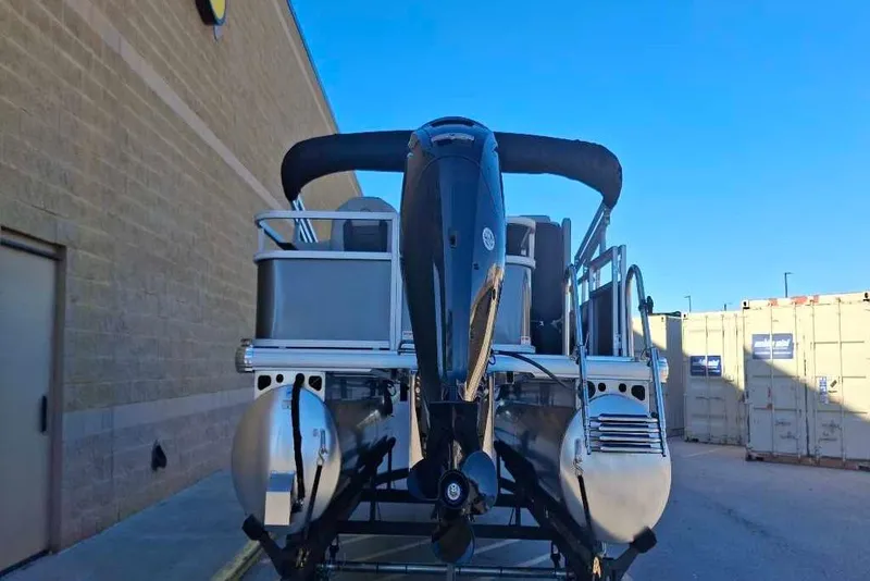 Slide: The Image of 2026 Sun Tracker Bass Buggy 18 DLX pontoon boat with outboard motor, parked outdoors. - 38