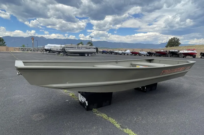 Slide: The Image of 2026 Tracker Grizzly 12 Jon boat displayed outdoors under cloudy sky. - 31