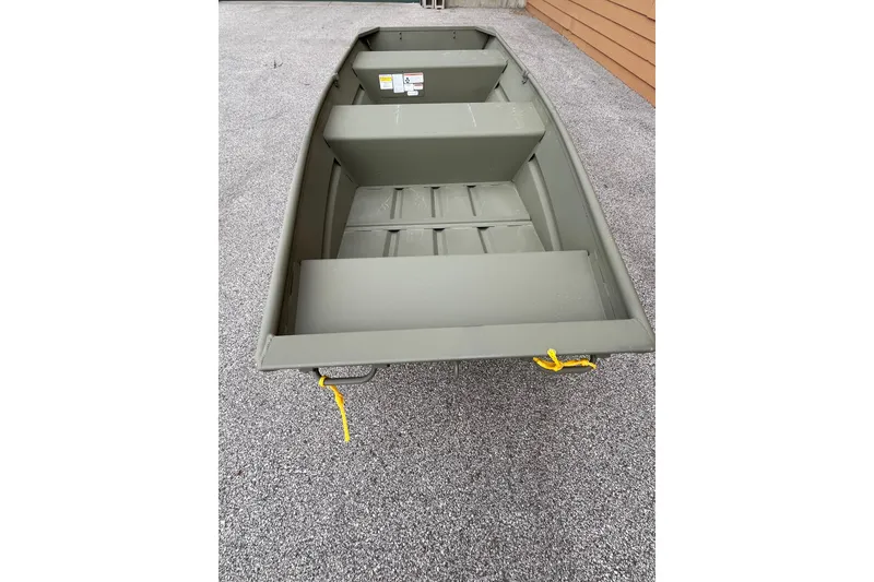 Slide: The Image of 2026 Tracker Grizzly 12 Jon boat on gravel, showcasing interior seating and storage. - 2