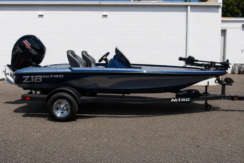 The Image of 2026 Nitro Z18 Pro fishing boat on trailer, side view, parked outdoors. - 0