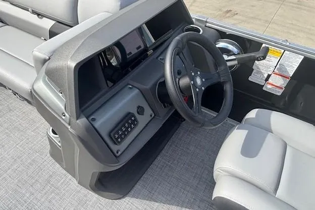 Slide: The Image of 2026 Sun Tracker Party Barge 22 RF DLX steering console with modern controls and seating. - 18