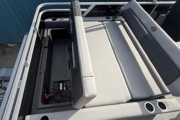 Slide: The Image of 2026 Sun Tracker Party Barge 22 RF DLX seating area with storage and cup holders. - 27